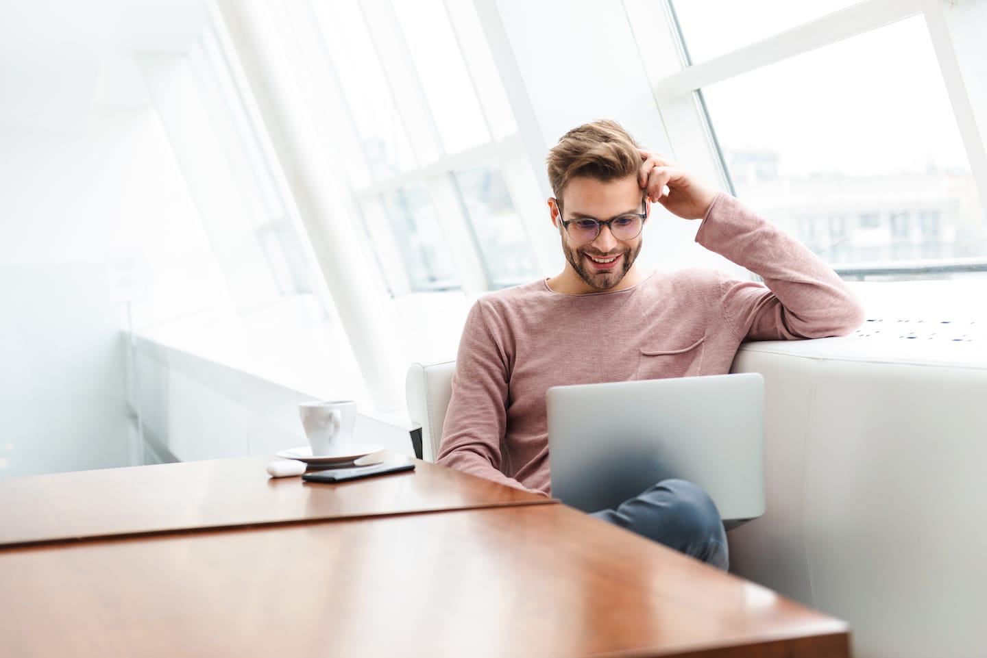 image of man wearing earbuds working on laptop com KGP8PWK